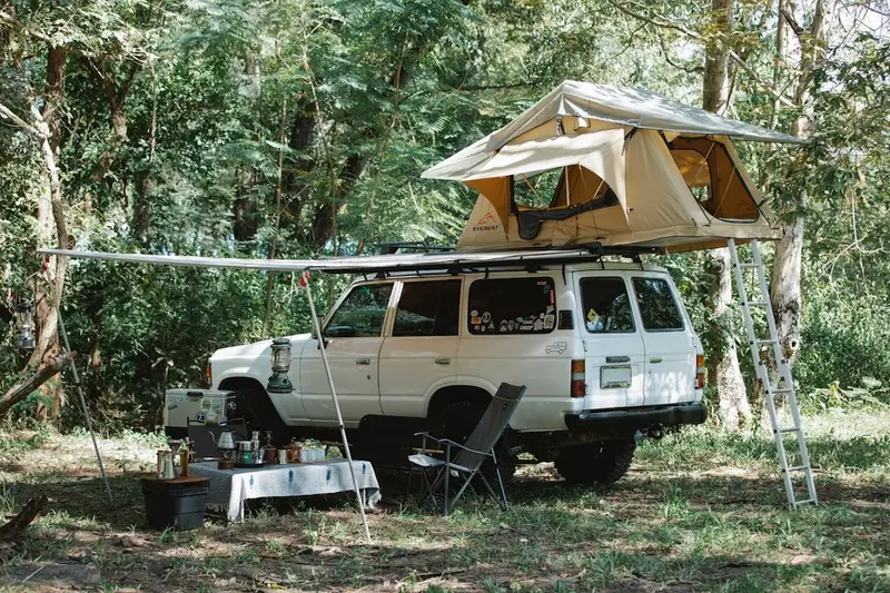 Toyota Land Cruiser parked in wooded campsite – Journey Overland Expedition